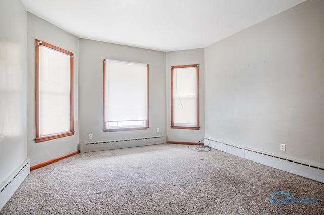 carpeted spare room with baseboard heating