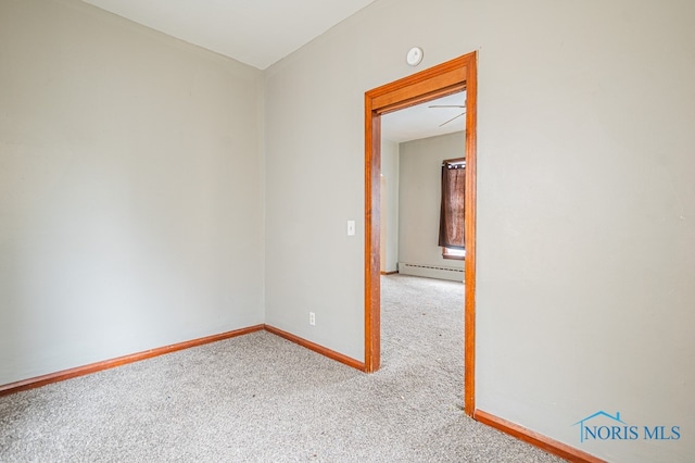 carpeted empty room featuring a baseboard radiator