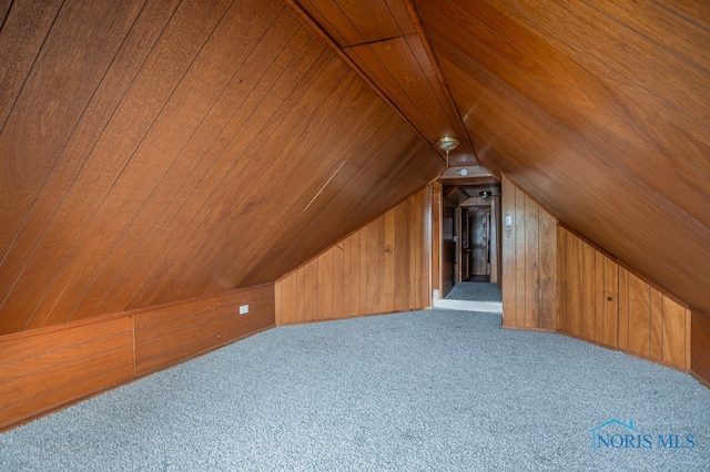 additional living space featuring wood walls, lofted ceiling, light carpet, and wooden ceiling