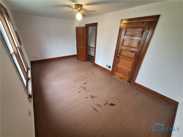 unfurnished room featuring hardwood / wood-style floors, ceiling fan, and radiator heating unit