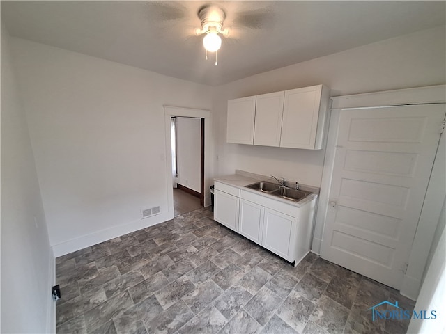 kitchen featuring white cabinets, ceiling fan, and sink