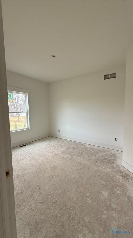 spare room featuring visible vents and baseboards