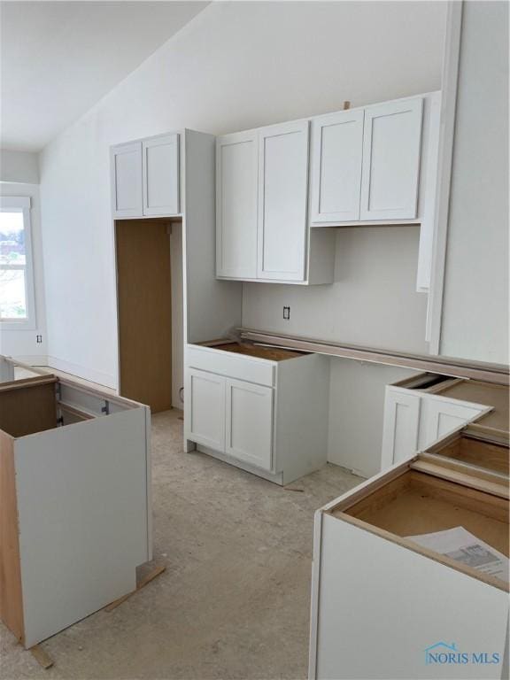 kitchen with lofted ceiling and white cabinets