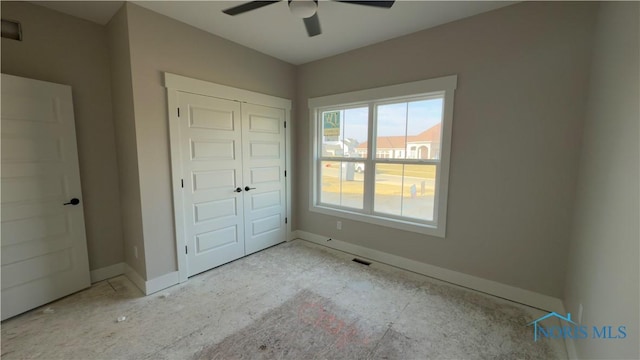 unfurnished bedroom with a closet, visible vents, ceiling fan, and baseboards