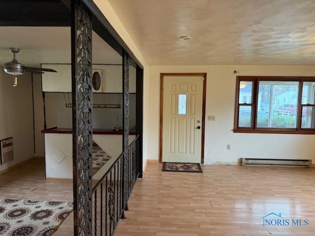 foyer entrance featuring light hardwood / wood-style floors, ceiling fan, and a baseboard heating unit