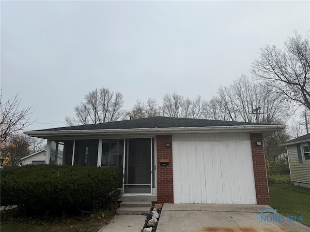 view of front of home with a garage and a sunroom