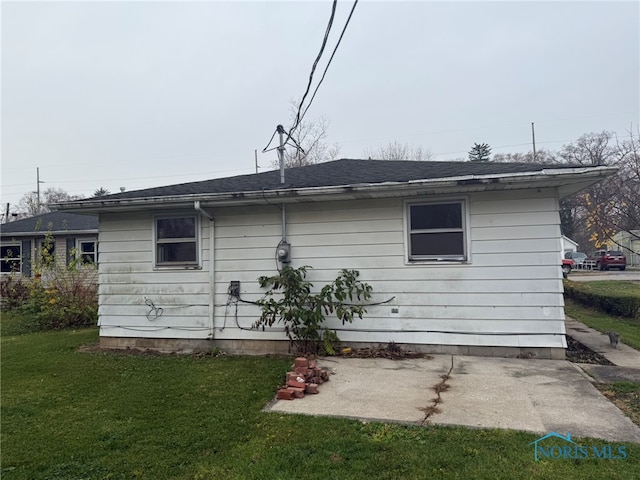 back of property featuring a lawn and a patio