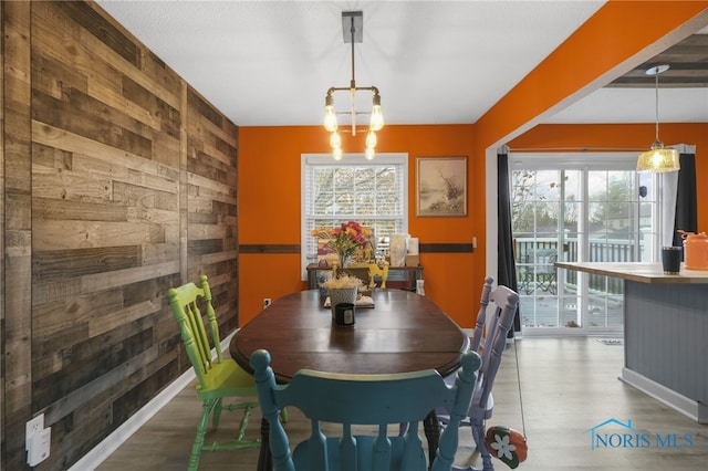 dining space with wood walls and a healthy amount of sunlight