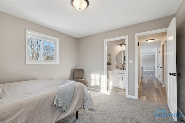 bedroom featuring wood-type flooring and ensuite bath