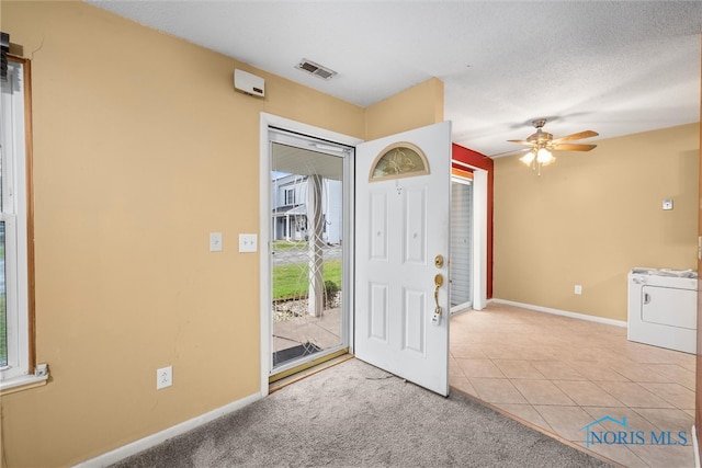 carpeted entryway featuring ceiling fan and a textured ceiling