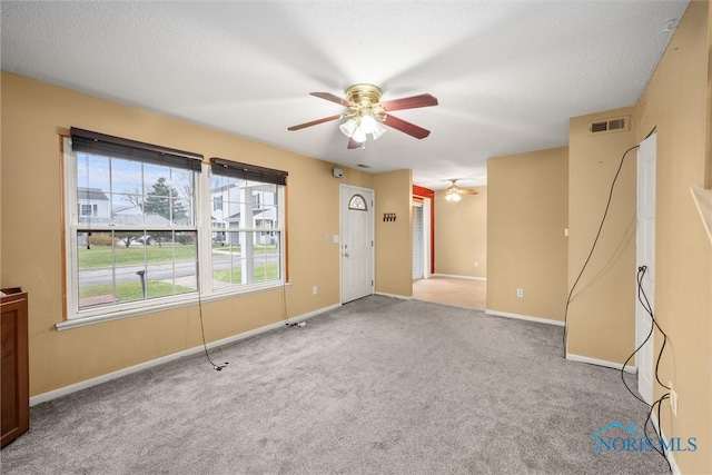 spare room with ceiling fan, carpet, and a textured ceiling