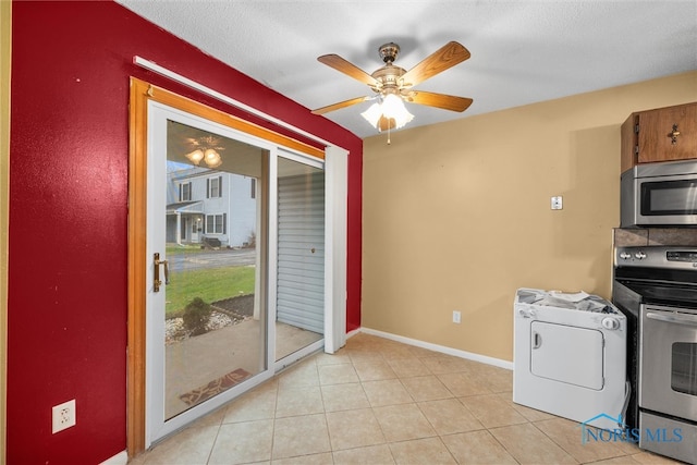 kitchen featuring ceiling fan, washer / clothes dryer, a textured ceiling, light tile patterned flooring, and appliances with stainless steel finishes