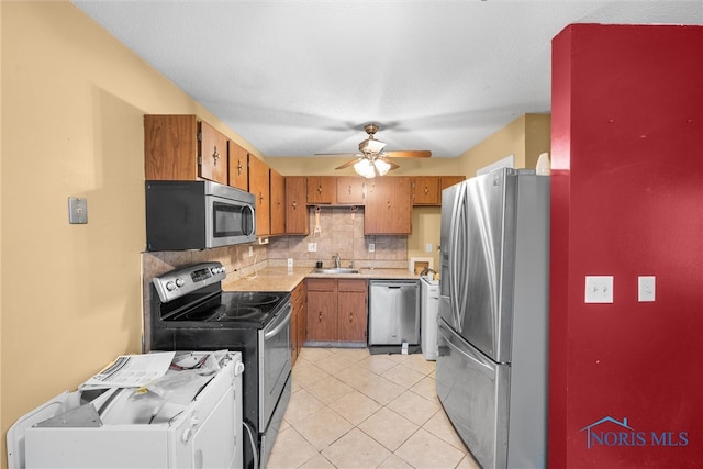 kitchen featuring ceiling fan, sink, backsplash, light tile patterned floors, and appliances with stainless steel finishes