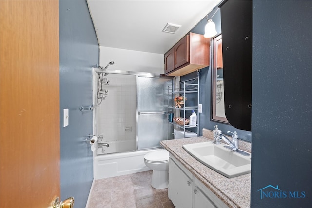 full bathroom featuring shower / bath combination with glass door, tile patterned floors, vanity, and toilet