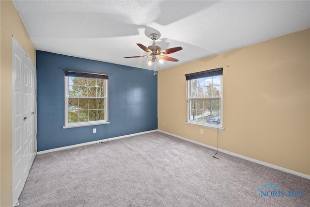 carpeted spare room with ceiling fan and a textured ceiling