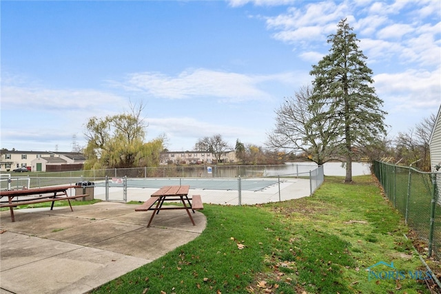 view of yard featuring tennis court and a water view