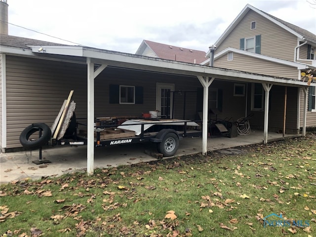 back of property featuring a yard and a carport