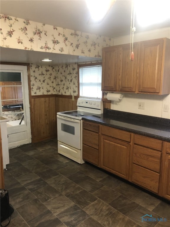 kitchen featuring wood walls and white electric range