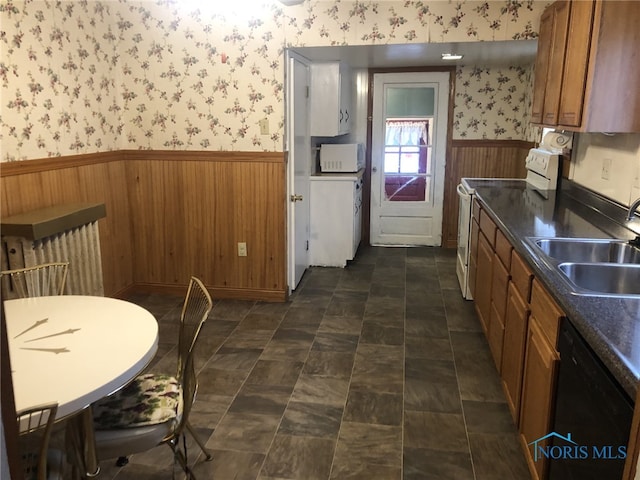 kitchen with white appliances, sink, and wooden walls