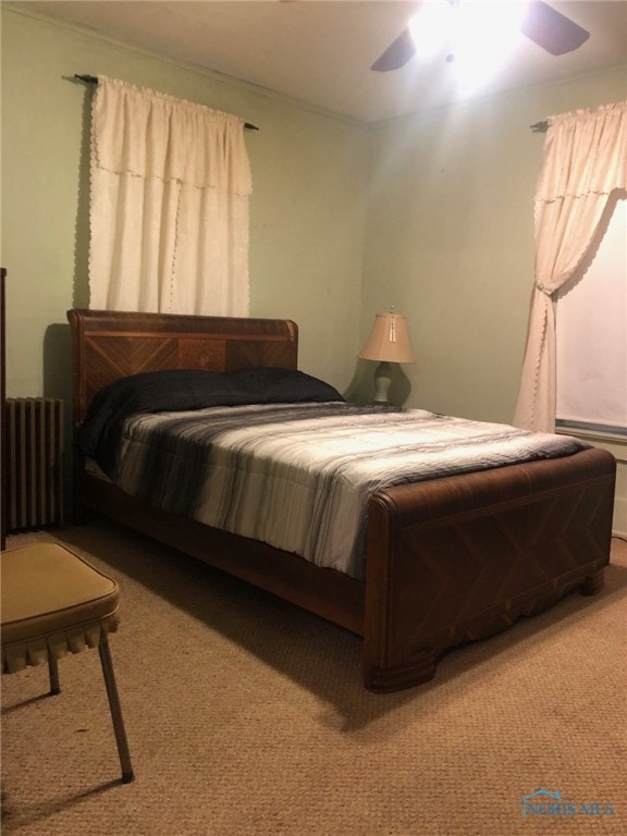 carpeted bedroom with radiator and ceiling fan