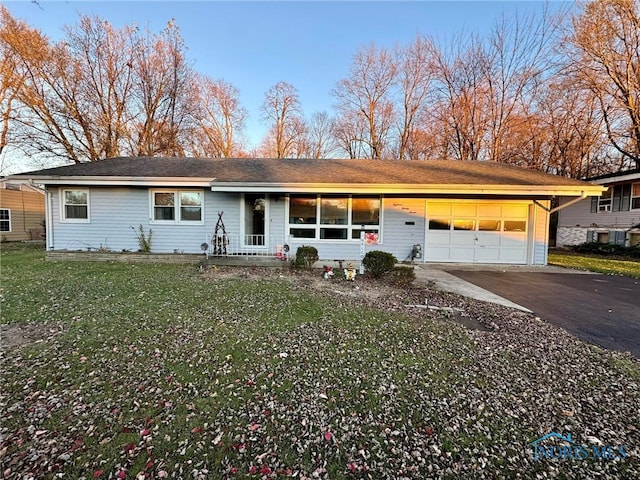 single story home featuring a garage and a front lawn