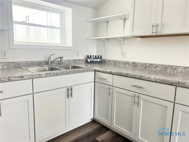 kitchen with dark hardwood / wood-style floors, white cabinetry, and sink