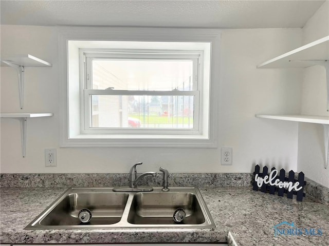 kitchen featuring a textured ceiling and sink