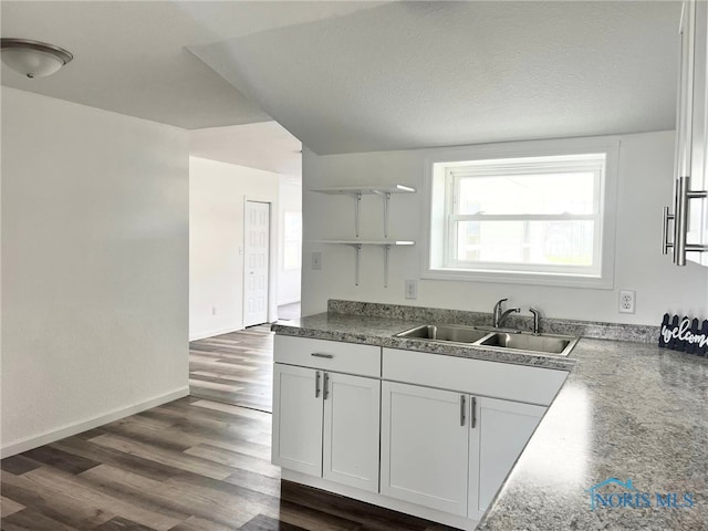 kitchen featuring lofted ceiling, white cabinets, sink, a textured ceiling, and dark hardwood / wood-style flooring