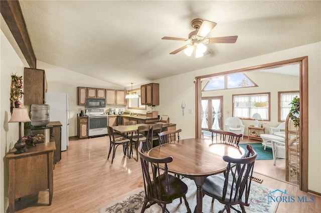 dining space with vaulted ceiling with beams, ceiling fan, and light hardwood / wood-style floors