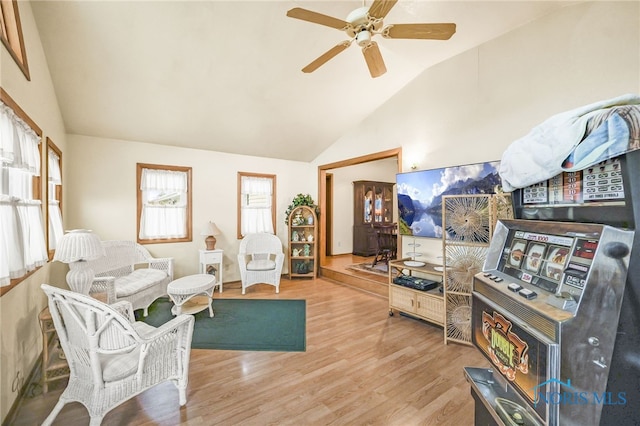 living room featuring ceiling fan, lofted ceiling, and light wood-type flooring