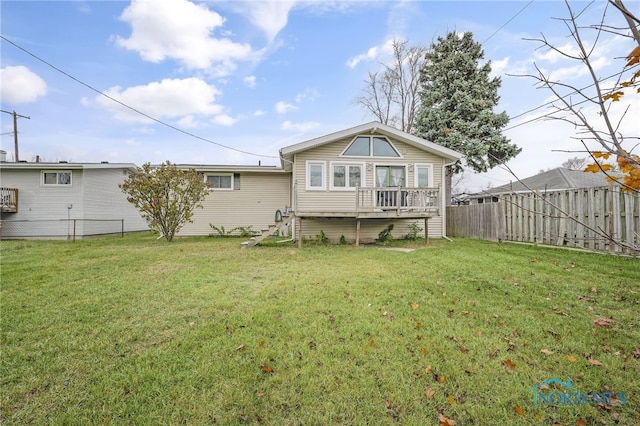 rear view of house with a wooden deck and a yard