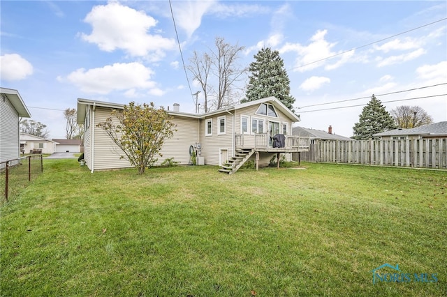 back of house featuring a lawn and a deck