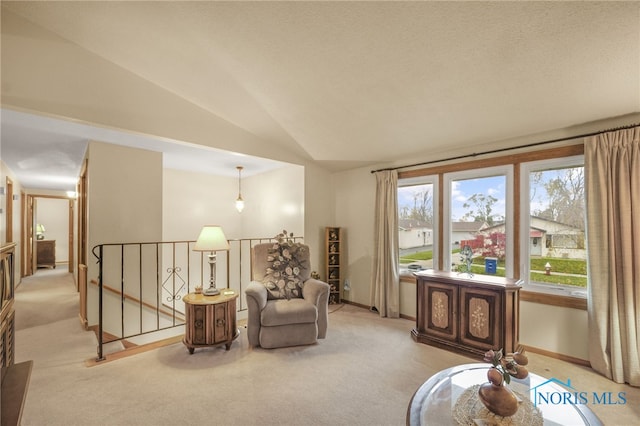 sitting room with a textured ceiling, light carpet, and lofted ceiling