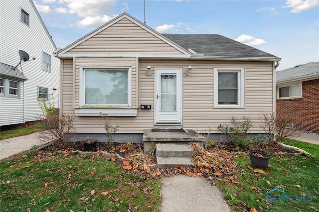 bungalow-style home with a front lawn