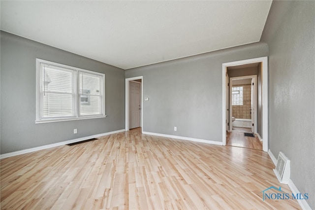 spare room featuring a healthy amount of sunlight and light wood-type flooring