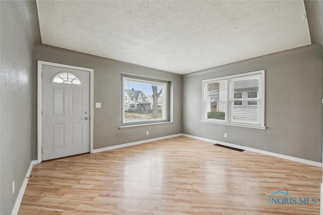 entrance foyer with a textured ceiling and light wood-type flooring