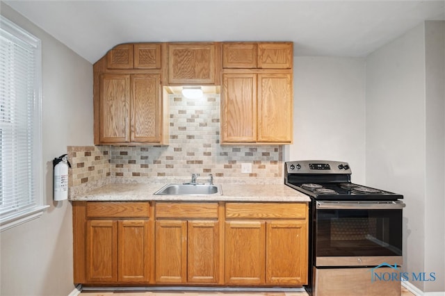 kitchen with stainless steel range with electric stovetop, sink, and backsplash