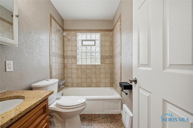 full bathroom featuring vanity, toilet, and tiled shower / bath