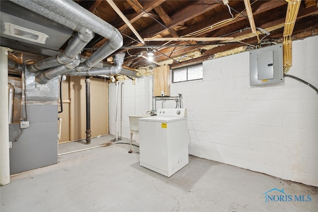 basement featuring washer / dryer, electric panel, heating unit, and sink