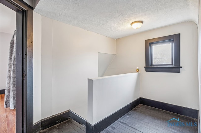 interior space with a textured ceiling and hardwood / wood-style flooring