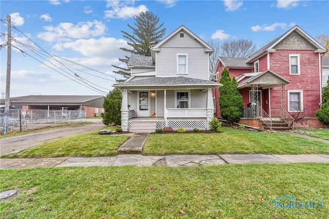 view of front of house with central AC, covered porch, and a front yard