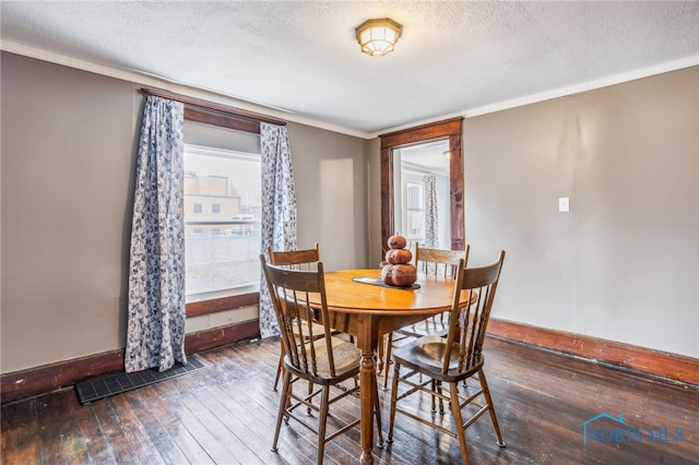 dining space featuring crown molding, dark hardwood / wood-style flooring, and a textured ceiling