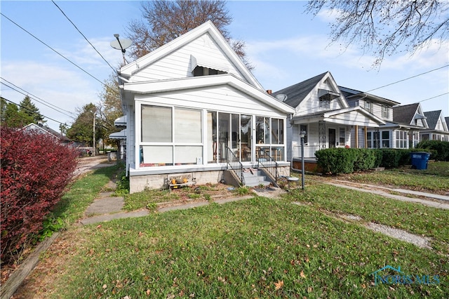 view of front of property with a front lawn and a sunroom