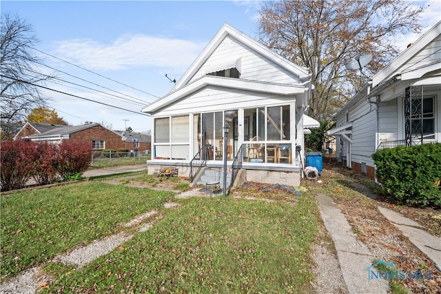 bungalow with a front yard and a sunroom