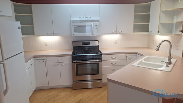 kitchen featuring white appliances, light hardwood / wood-style floors, white cabinetry, and sink