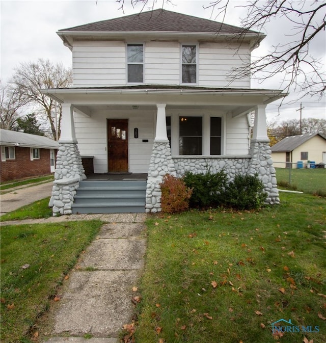 view of front of house with covered porch and a front lawn