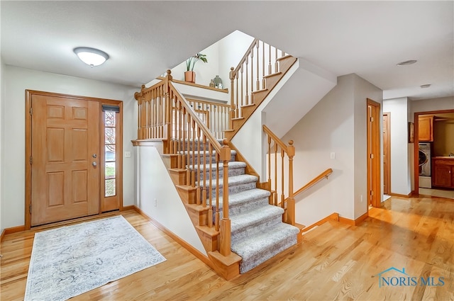 foyer with wood-type flooring and washer / dryer