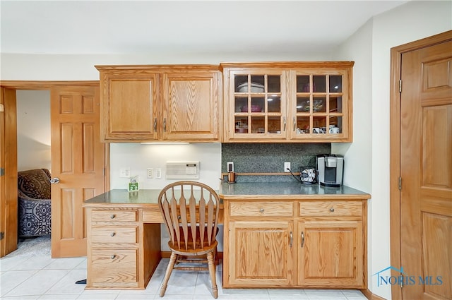 kitchen with tasteful backsplash, light tile patterned floors, and built in desk