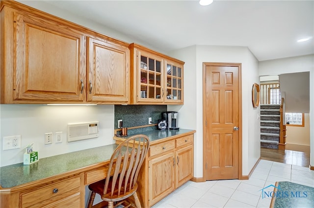 kitchen featuring decorative backsplash, built in desk, and light tile patterned floors