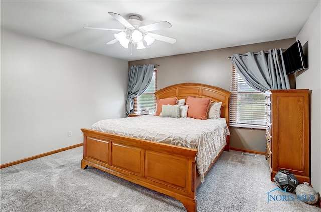 carpeted bedroom with multiple windows and ceiling fan